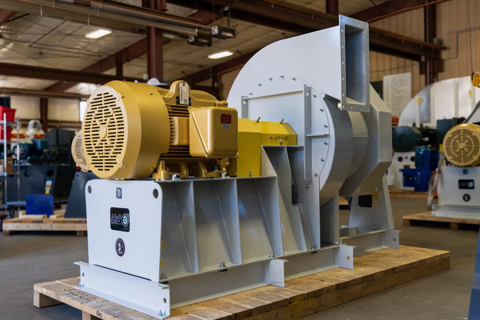 A large AirPro centrifugal fan with a gold motor, assembled on a shipping pallet.