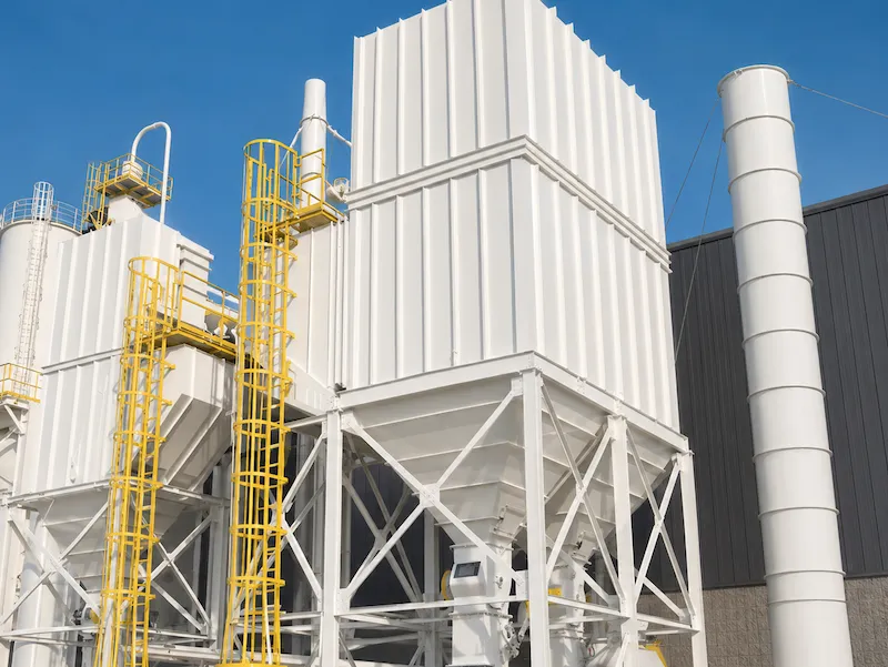 An outdoor dust collector with steel access platforms, caged ladders and stack ducting.